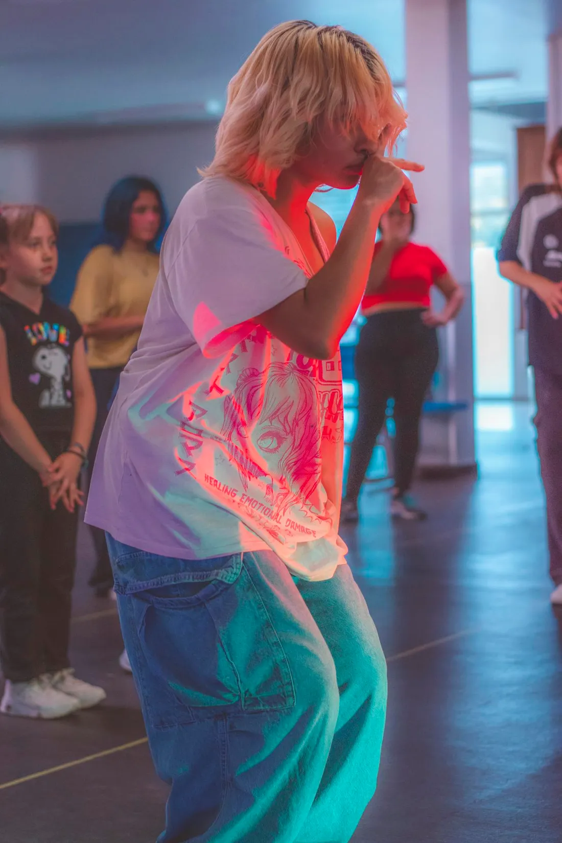 Young dancers in a vibrant dance class, highlighted by colorful neon lighting.